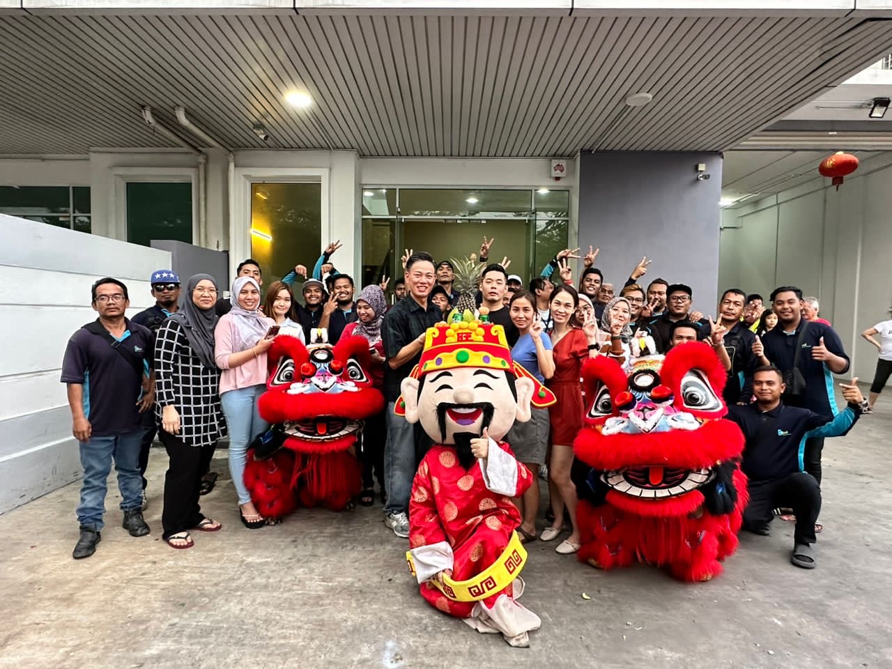 The EQool Enviro team gathered outside the office with two lion dance performers and a God of Fortune mascot during Chinese New Year