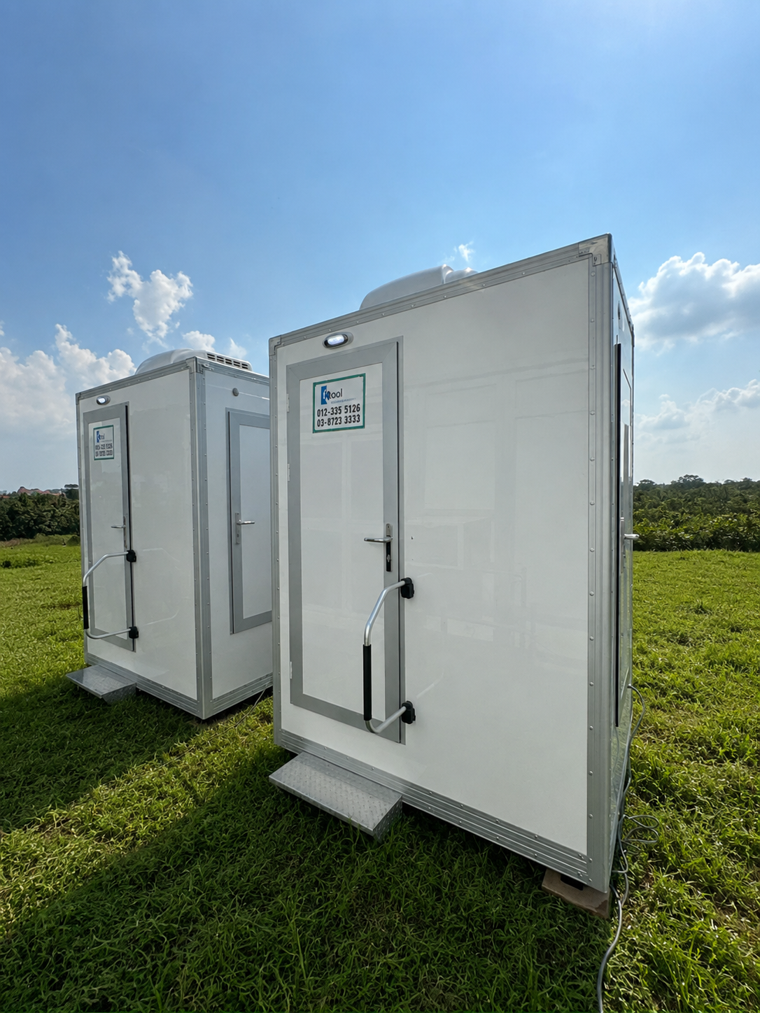 EQool Lux portable toilet units on a green grass field — premium eco-responsible sanitation Malaysia