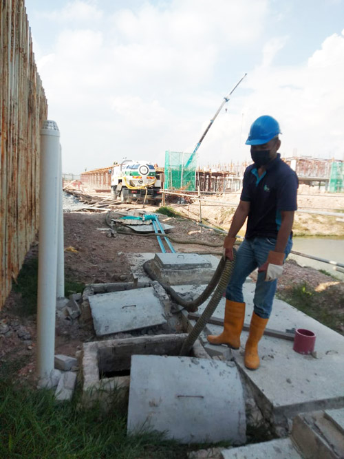 EQool Enviro team performing septic tank cleaning and vacuum pump service at a construction site